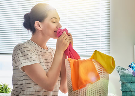 Woman smelling laundry washed in ozone water